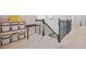 Bright hallway with decorative metal stair railing, desk and shelving unit with storage bins at 18144 Frame Bnd, Land O Lakes, FL 34638