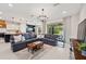 Open-concept living room with a modern chandelier, stylish decor, and sliding glass doors to the backyard at 18144 Frame Bnd, Land O Lakes, FL 34638
