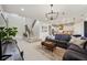 Bright living room next to the staircase and kitchen features modern lighting and comfortable seating at 18144 Frame Bnd, Land O Lakes, FL 34638