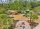 Overhead view of the community playground and fire pit with seating, set amongst mature trees and landscaping at 18144 Frame Bnd, Land O Lakes, FL 34638