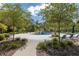 Poolside view of a splash pad and lounge chairs surrounded by lush landscaping and paved walkways at 18144 Frame Bnd, Land O Lakes, FL 34638