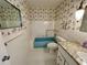 Bathroom showcasing blue tub, white tile and patterned wallpaper at 2070 World Parkway Blvd # 36, Clearwater, FL 33763