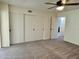 Bedroom featuring ceiling fan, carpet, sliding closet doors, and views to additional rooms at 2070 World Parkway Blvd # 36, Clearwater, FL 33763