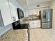 Modern kitchen featuring white cabinets, granite countertops, and stainless steel appliances at 2070 World Parkway Blvd # 36, Clearwater, FL 33763