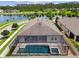 Aerial view of screened-in pool and fenced backyard with lake views at 21837 Briske Morning Ave, Land O Lakes, FL 34637