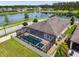 Overhead view of a private screened-in pool with spa, set against the backdrop of a tranquil lake at 21837 Briske Morning Ave, Land O Lakes, FL 34637