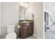 Cozy bathroom featuring a dark brown vanity and granite top with a view to the brick paver patio at 21837 Briske Morning Ave, Land O Lakes, FL 34637