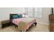 Cozy bedroom featuring bright windows, wood flooring, and neutral walls at 21837 Briske Morning Ave, Land O Lakes, FL 34637