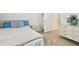 Bedroom with herringbone wood floors, and a full bed with blue pillows and a white dresser at 21837 Briske Morning Ave, Land O Lakes, FL 34637
