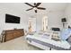 Bedroom with wood-look floors, ceiling fan, large flatscreen TV, and access to a walk-in closet at 21837 Briske Morning Ave, Land O Lakes, FL 34637