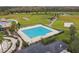 Aerial showcasing a vast community pool, perfect for exercise and relaxation, with views of surrounding green fields at 21837 Briske Morning Ave, Land O Lakes, FL 34637