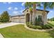 Lush landscaping frames the home with a three-car garage and inviting entrance at 21837 Briske Morning Ave, Land O Lakes, FL 34637