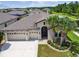 Charming single-story home showcasing a three-car garage, arched entry, and beautiful landscaping at 21837 Briske Morning Ave, Land O Lakes, FL 34637