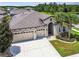 Inviting single-story house with three-car garage, an arched entryway, and well-manicured landscaping at 21837 Briske Morning Ave, Land O Lakes, FL 34637