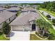 Attractive single-story home with a three-car garage, arched entryway, and lush tropical landscaping at 21837 Briske Morning Ave, Land O Lakes, FL 34637