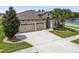 A front exterior view of the property, with a well-manicured lawn and three-car garage at 21837 Briske Morning Ave, Land O Lakes, FL 34637