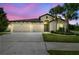 Home exterior at twilight; beautiful curb appeal enhanced by the illuminated windows at 21837 Briske Morning Ave, Land O Lakes, FL 34637