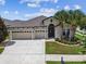 A front exterior view of the property, with a well-manicured lawn and three-car garage at 21837 Briske Morning Ave, Land O Lakes, FL 34637