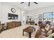 Cozy living room with beautiful wood floors, leather sofa, desk, and a large flatscreen TV at 21837 Briske Morning Ave, Land O Lakes, FL 34637
