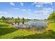 A calming view of the pond, with trees and homes surrounding the water at 21837 Briske Morning Ave, Land O Lakes, FL 34637