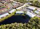 Aerial view of the community with a central pond, mature trees, amenities, and ample parking at 25050 Sandhill Blvd # 8B1, Punta Gorda, FL 33983
