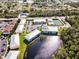 This aerial showcases the pool, tennis court, and lake views in this well-maintained community at 25050 Sandhill Blvd # 8B1, Punta Gorda, FL 33983