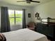 Bedroom with neutral tones, nice furnishings, and a window overlooking the green landscape at 25050 Sandhill Blvd # 8B1, Punta Gorda, FL 33983