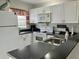 Bright kitchen features white cabinets, black countertops, and modern appliances at 25050 Sandhill Blvd # 8B1, Punta Gorda, FL 33983