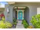 Attractive front entrance with a modern blue glass door, arched doorway, elegant house numbers and manicured landscaping at 2581 61St S Ave, St Petersburg, FL 33712