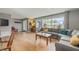 Inviting living room with a comfortable gray sofa, light hardwood floors, and large windows offering natural light at 2581 61St S Ave, St Petersburg, FL 33712