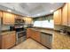 Well-lit kitchen with stainless steel appliances, granite countertops, and neutral colored cabinets at 3035 Countryside Blvd # 16B, Clearwater, FL 33761