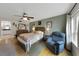 This main bedroom has a queen bed, a soft chair, and wood flooring at 3035 Countryside Blvd # 16B, Clearwater, FL 33761