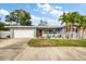 Inviting single-story home featuring a red front door and a well-maintained lawn at 3173 Fountainhead Dr, Largo, FL 33770
