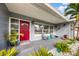 Cozy covered front porch with seating, potted plants, and a decorative red door at 3173 Fountainhead Dr, Largo, FL 33770