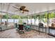 Enclosed lanai with brick floors, ceiling fan, and a table with seating, perfect for outdoor enjoyment at 3173 Fountainhead Dr, Largo, FL 33770