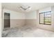 A bedroom with a large window offering natural light, undergoing renovation with visible wall framework and a concrete floor at 326 Moorings Cove Dr # 2B, Tarpon Springs, FL 34689