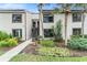 Charming two-story condo with lush landscaping, trees, and inviting entrance at 326 Moorings Cove Dr # 2B, Tarpon Springs, FL 34689