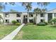 Inviting two-story condo with charming exterior, lush landscaping, and sidewalk leading to the entrance at 326 Moorings Cove Dr # 2B, Tarpon Springs, FL 34689