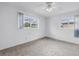 Spacious bedroom with plush carpet, a ceiling fan, and bright natural light from two windows at 3652 18Th N Ave, St Petersburg, FL 33713