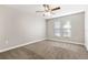 Bright bedroom featuring neutral walls, plush carpeting, and a modern ceiling fan at 3753 Thornbush Ln, New Port Richey, FL 34655