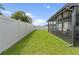 Spacious backyard with manicured lawn and screened-in patio at 39024 Harlow Rose Dr, Zephyrhills, FL 33540
