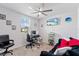This is a bedroom or office space with a ceiling fan, large window, TV, couch and desk area at 39024 Harlow Rose Dr, Zephyrhills, FL 33540