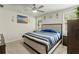 Comfortable bedroom featuring a queen bed, soft carpeting, and natural light from the windows at 39024 Harlow Rose Dr, Zephyrhills, FL 33540
