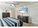 Inviting bedroom with dark dressers, ceiling fan, and a television for entertainment at 39024 Harlow Rose Dr, Zephyrhills, FL 33540