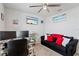 This is a bedroom or office space with a ceiling fan, beach artwork, couch and desk area at 39024 Harlow Rose Dr, Zephyrhills, FL 33540