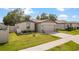 Charming single-story home features a two-car garage, well-maintained lawn, and lovely landscaping at 39024 Harlow Rose Dr, Zephyrhills, FL 33540