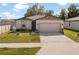 Charming single-story home features a two-car garage, well-maintained lawn, and lovely landscaping at 39024 Harlow Rose Dr, Zephyrhills, FL 33540