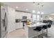 Modern kitchen with stainless steel appliances, an island with seating, and open to the living room at 39024 Harlow Rose Dr, Zephyrhills, FL 33540