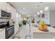 Bright kitchen with granite countertops, stainless steel appliances, and open view to the living room at 39024 Harlow Rose Dr, Zephyrhills, FL 33540