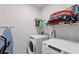 A laundry room featuring a newer model washer and dryer as well as some storage and supplies at 39024 Harlow Rose Dr, Zephyrhills, FL 33540